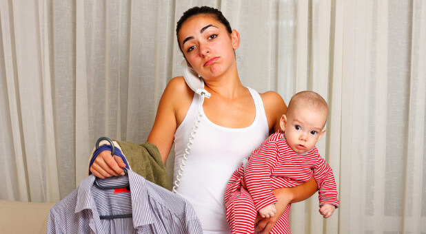 mom holding baby and talking on phone