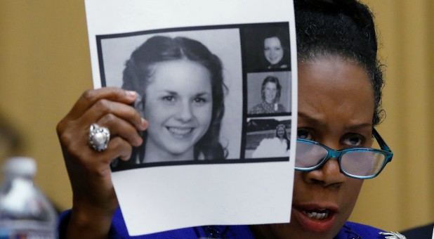Rep. Sheila Jackson Lee, D-Texas, holds up pictures of women who've accused U.S. Senate candidate Roy Moore of sexual misconduct.