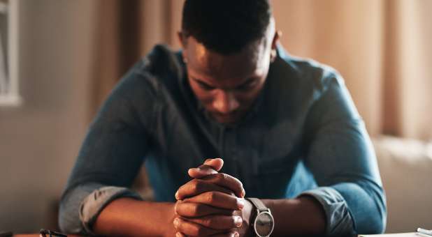 Man bowing his head in prayer.